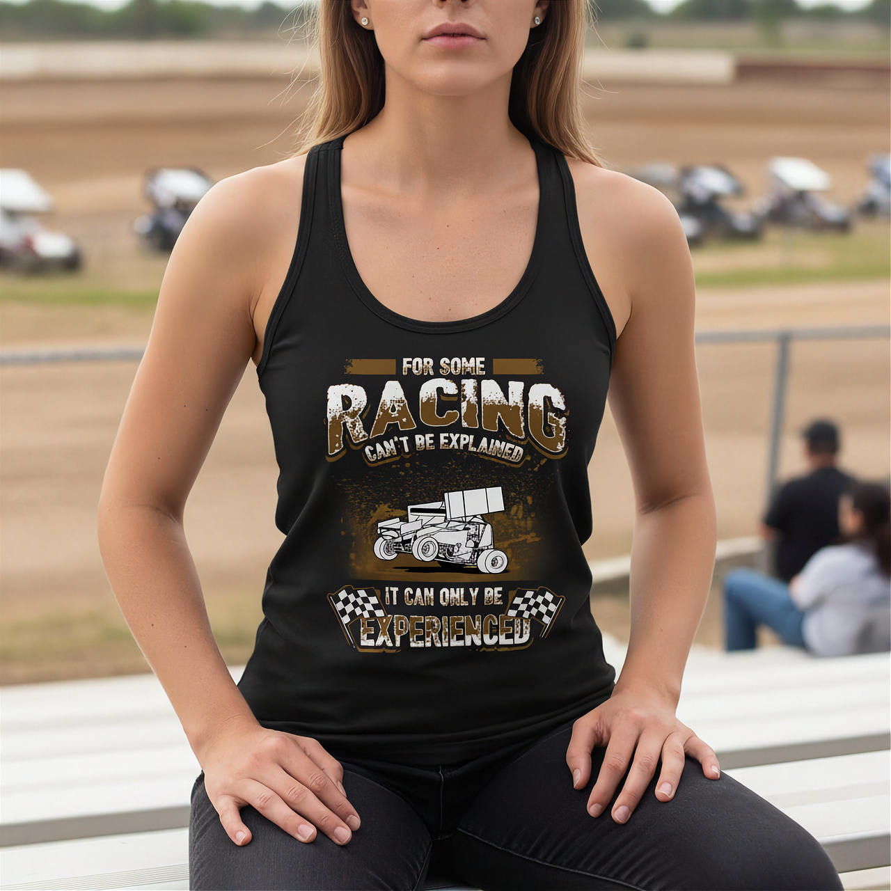 Woman wearing a black tank top with racing-themed text at a race track.