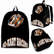 A young kart racer aged 8 to 12 standing in an outdoor track pit lane next to a sleek orange racing kart, wearing a custom orange go-kart track backpack with thick black padded shoulder straps while holding a racing helmet.