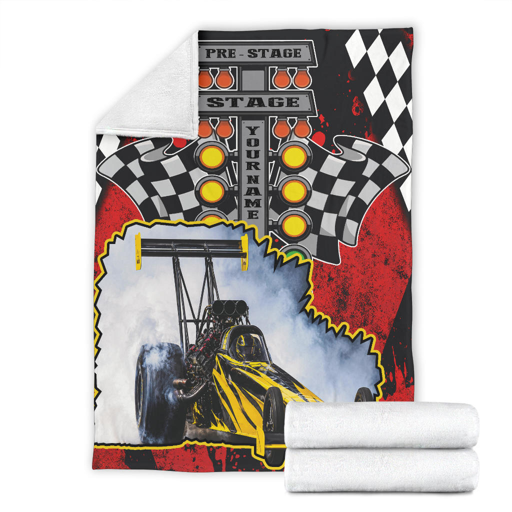Full view of the personalized dragster blanket with a folded corner revealing white microfleece backing.