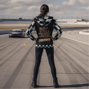 Woman wearing a sherpa jacket with racing text on the back at a race track