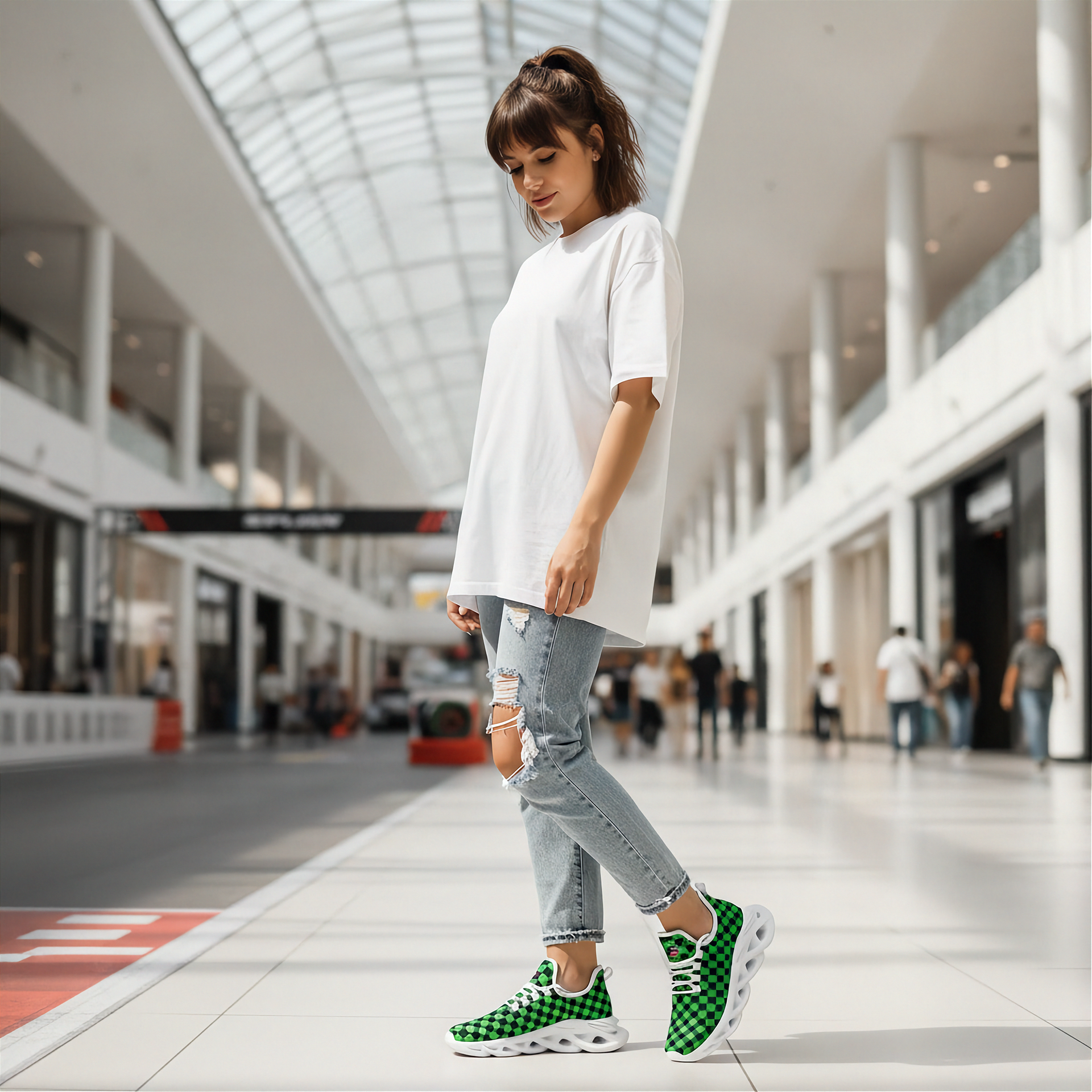 Woman wearing a white oversized shirt, ripped jeans, and green checkered sneakers in a modern indoor mall.