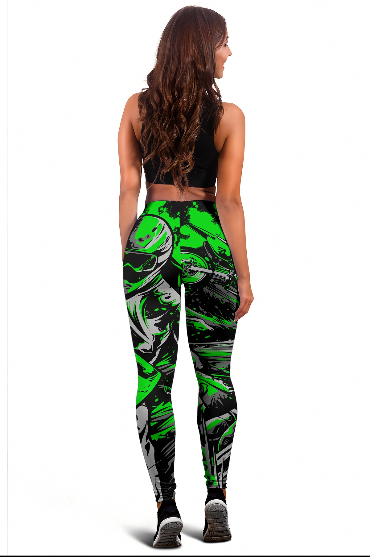 A woman shown from the back wearing high-waisted athletic leggings with a bold green, black, and gray abstract brushstroke pattern, paired with a black sports bra and black sneakers, against a plain white background.