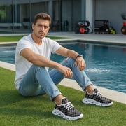 Man sitting by a pool wearing checkered sneakers