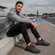 Man sitting on a race track wearing checkered shoes