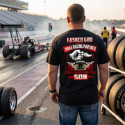 Heartfelt drag racing apparel featuring a fist-bump graphic and the text "I Asked God For A Drag Racing Partner He Sent Me My Son," available in t-shirts, tanks, and hoodies.