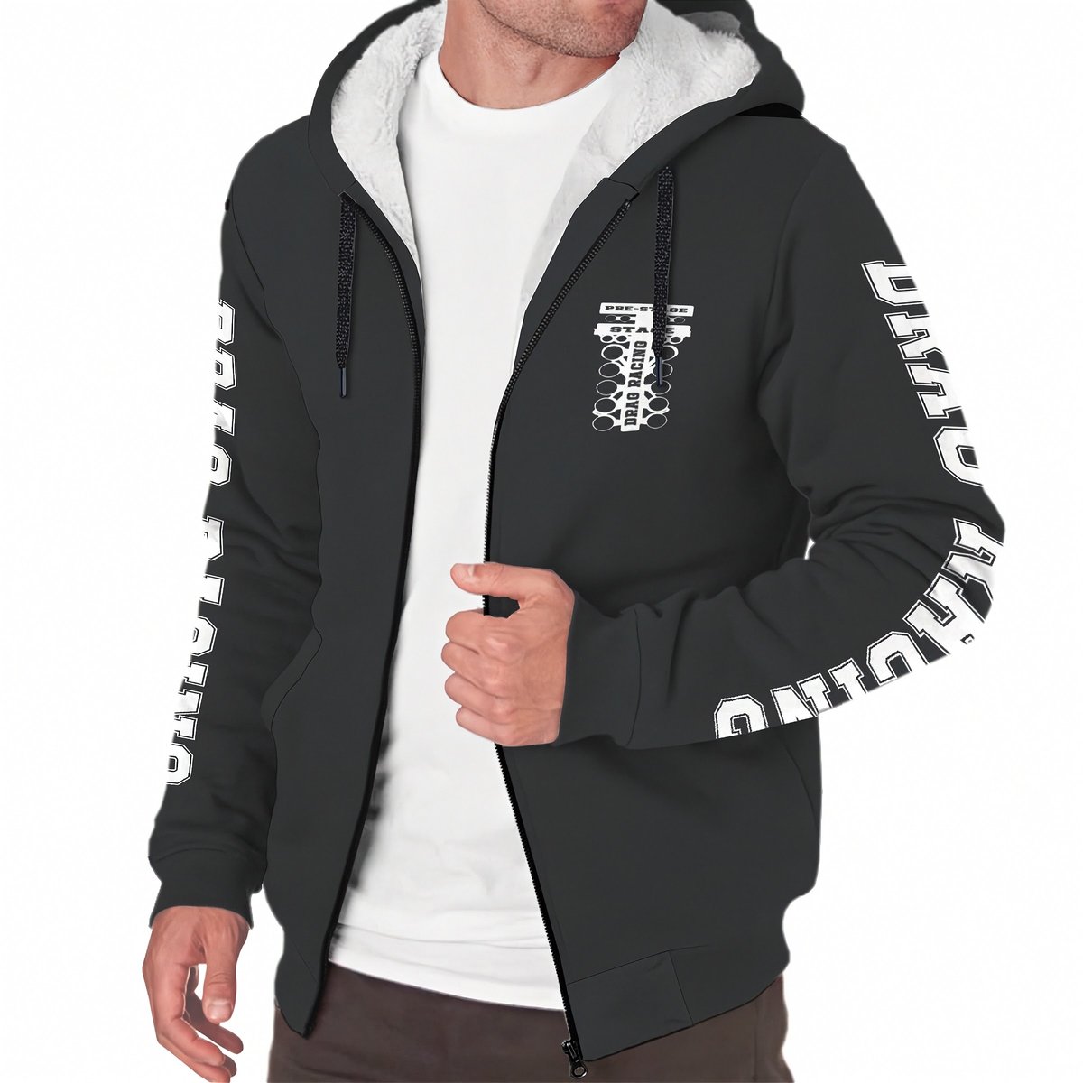 A man wearing a black zip-up hoodie with a white sherpa-lined hood, featuring white graphic prints on the chest and down both sleeves, layered over a white t-shirt.