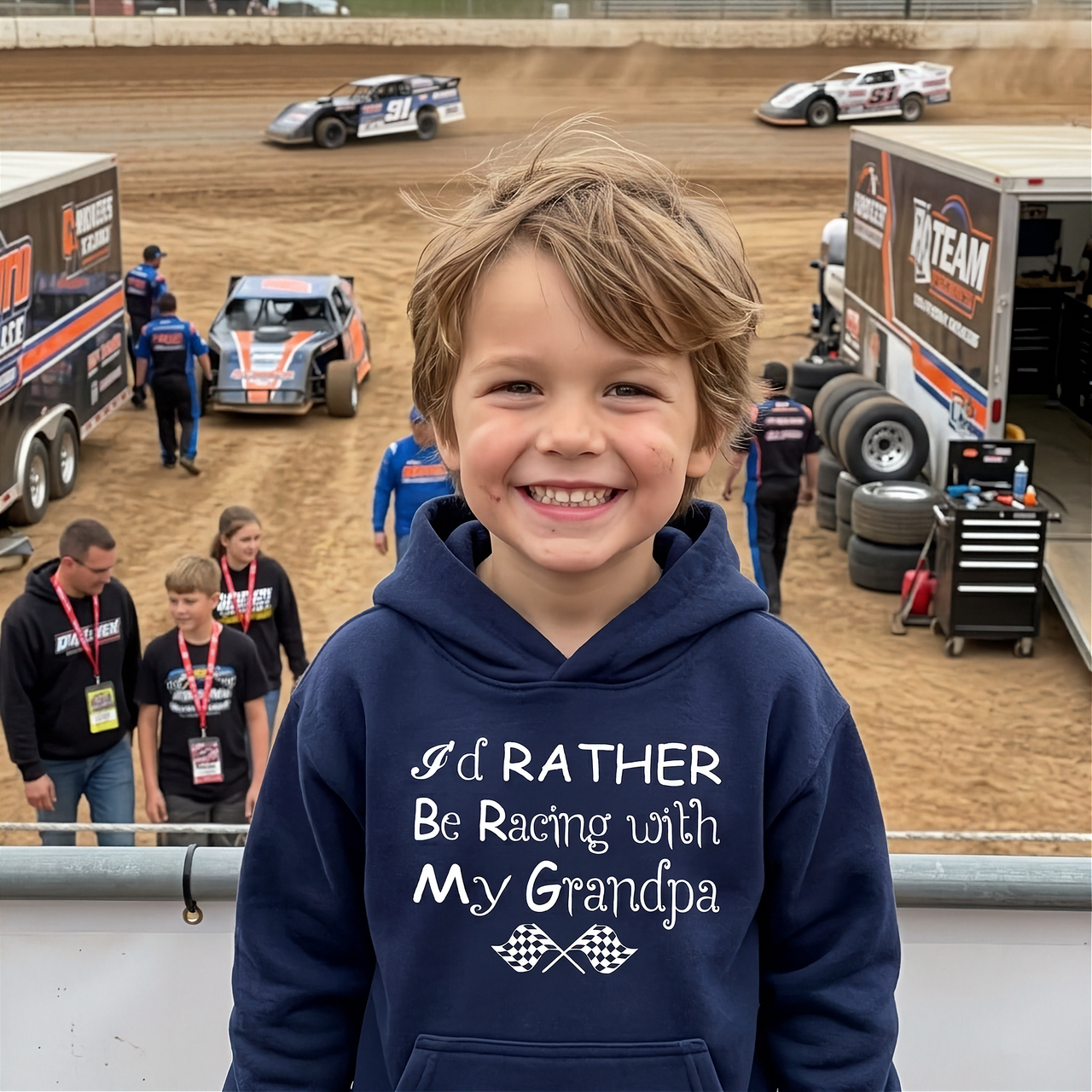 Child wearing a hoodie with racing-themed text at a race track.