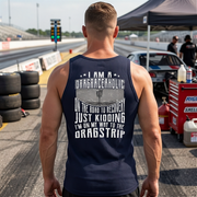 Man wearing a tank top with drag racing-themed text at a race track.