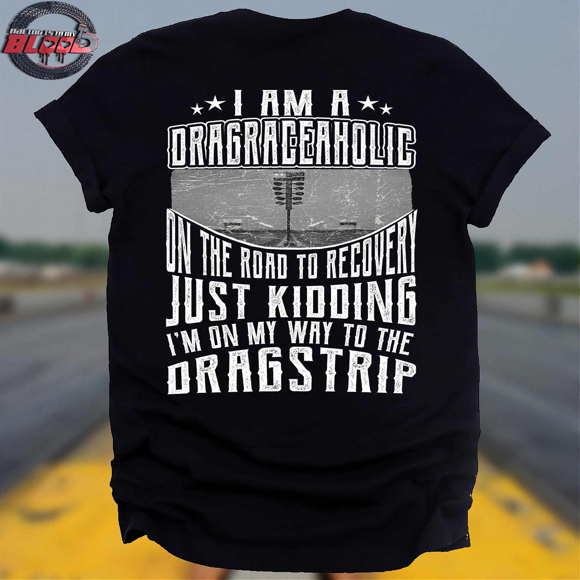 Black t-shirt with white text on a blurred drag racing track background
