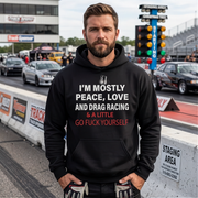 Man wearing a black hoodie with text at a drag racing event