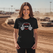Woman wearing a black t-shirt with racing design at a race track.