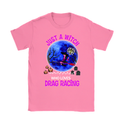 A pink short-sleeve crewneck t-shirt featuring a colorful graphic of a witch riding a red racecar in front of a blue full moon, with the text 'JUST A WITCH WHO LOVES DRAG RACING' in pink and white.