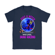 A navy blue short-sleeve t-shirt with a graphic print on the front. The graphic features a blue full moon, a witch riding a broomstick, jack-o'-lanterns, tombstones, and the text 'JUST A WITCH WHO LOVES DRAG RACING' in pink and white lettering.