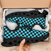 Black and blue checkered sneakers in a box with a hand holding one shoe.