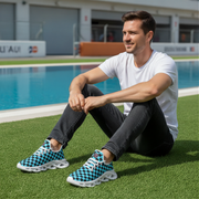 Man sitting by a pool wearing checkered shoes