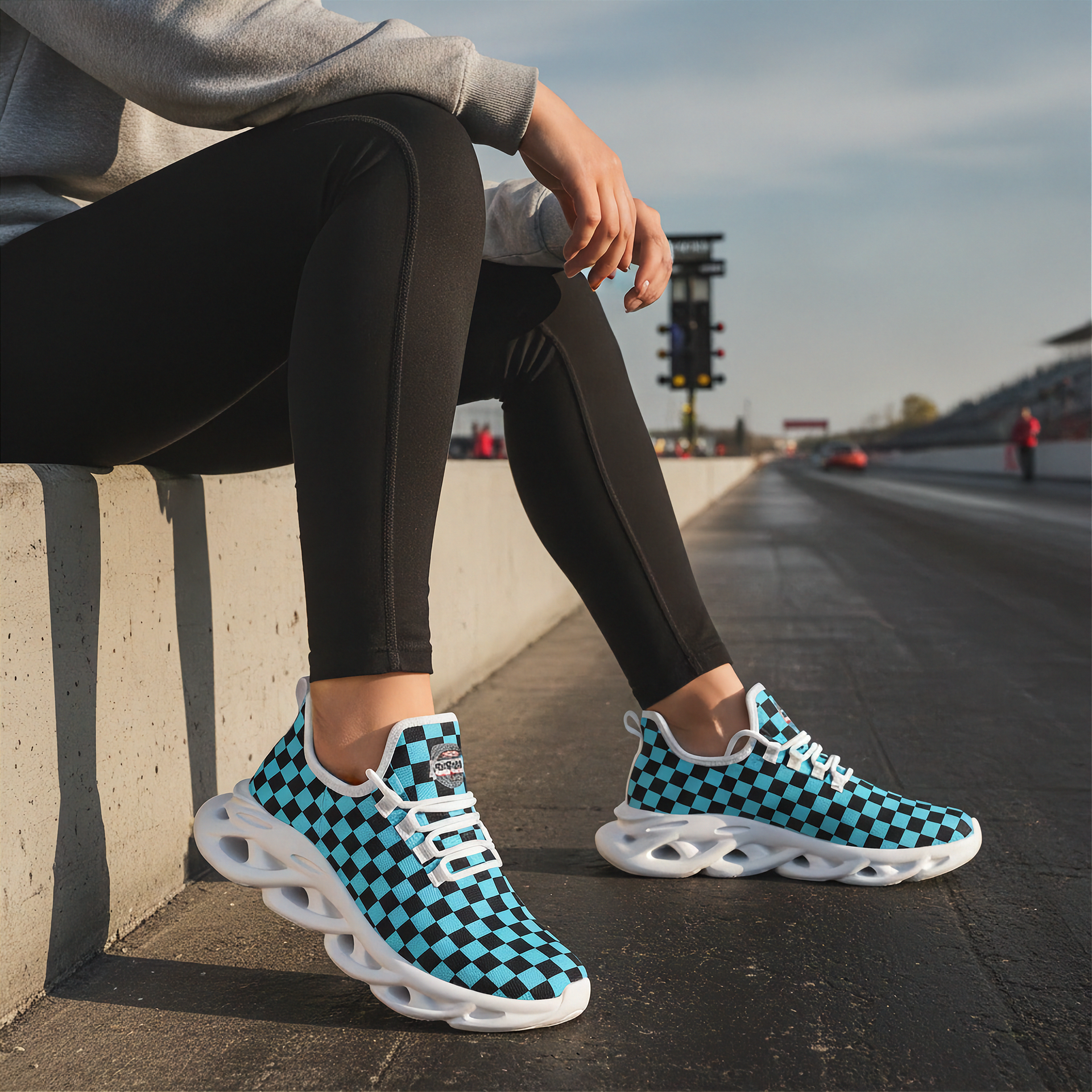 Woman wearing blue and black checkered shoes on a race track.