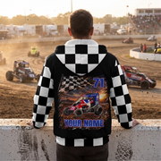 Man watching midget racing at sunset, wearing a checkered sherpa jacket with car artwork, number 71, and “YOUR NAME.”