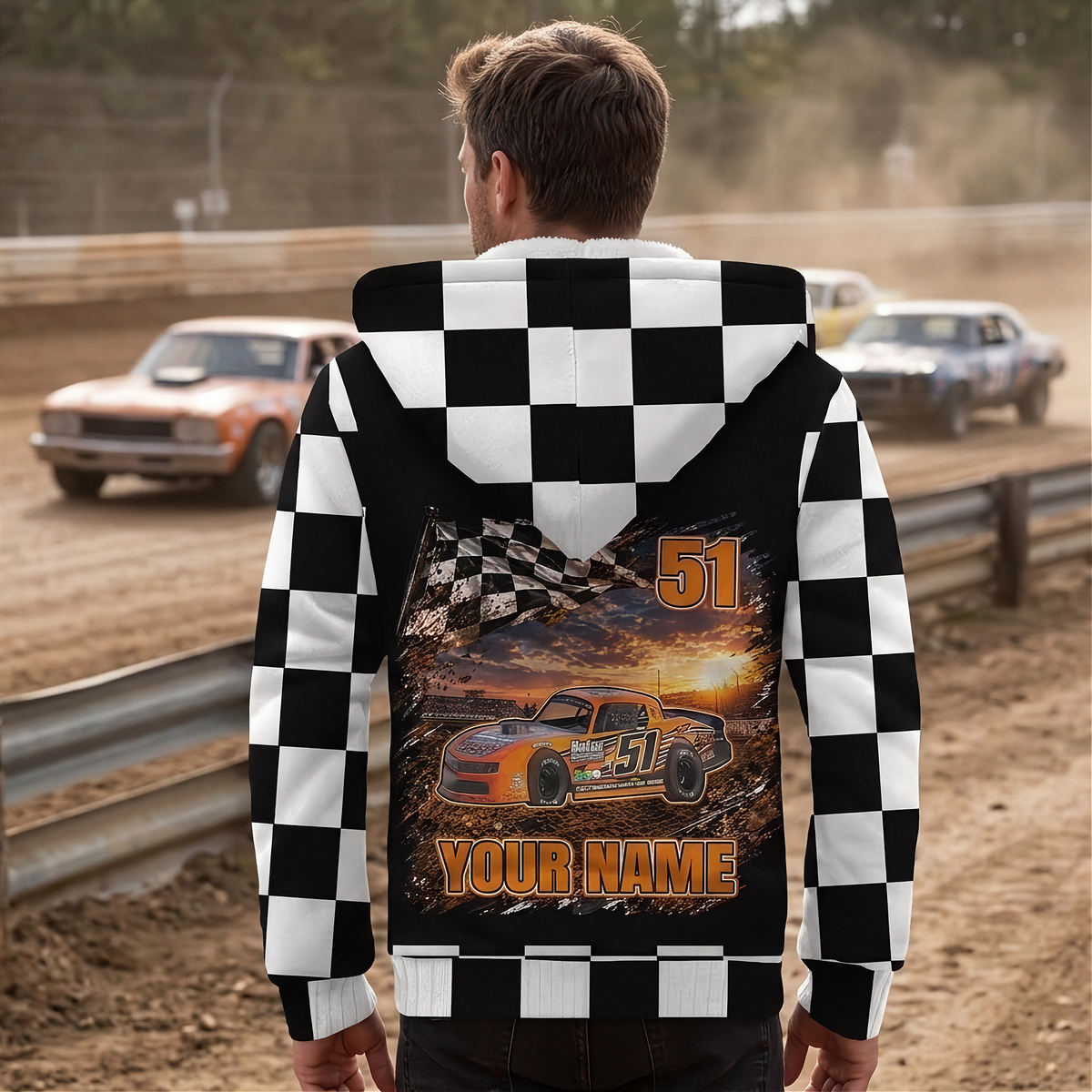 Man watching stock cars at a dirt track, showing the personalized car, name, and number design on his jacket back.
