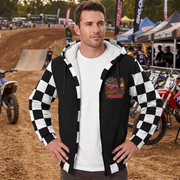 Man wearing a dirt bike sherpa jacket at the track, showing the custom chest graphic, checkered sleeves, and white lining.