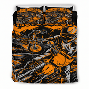 A motocross-themed bedding set featuring a duvet cover and two matching pillowcases with a bold graphic print of riders on bikes in orange, black, and gray.