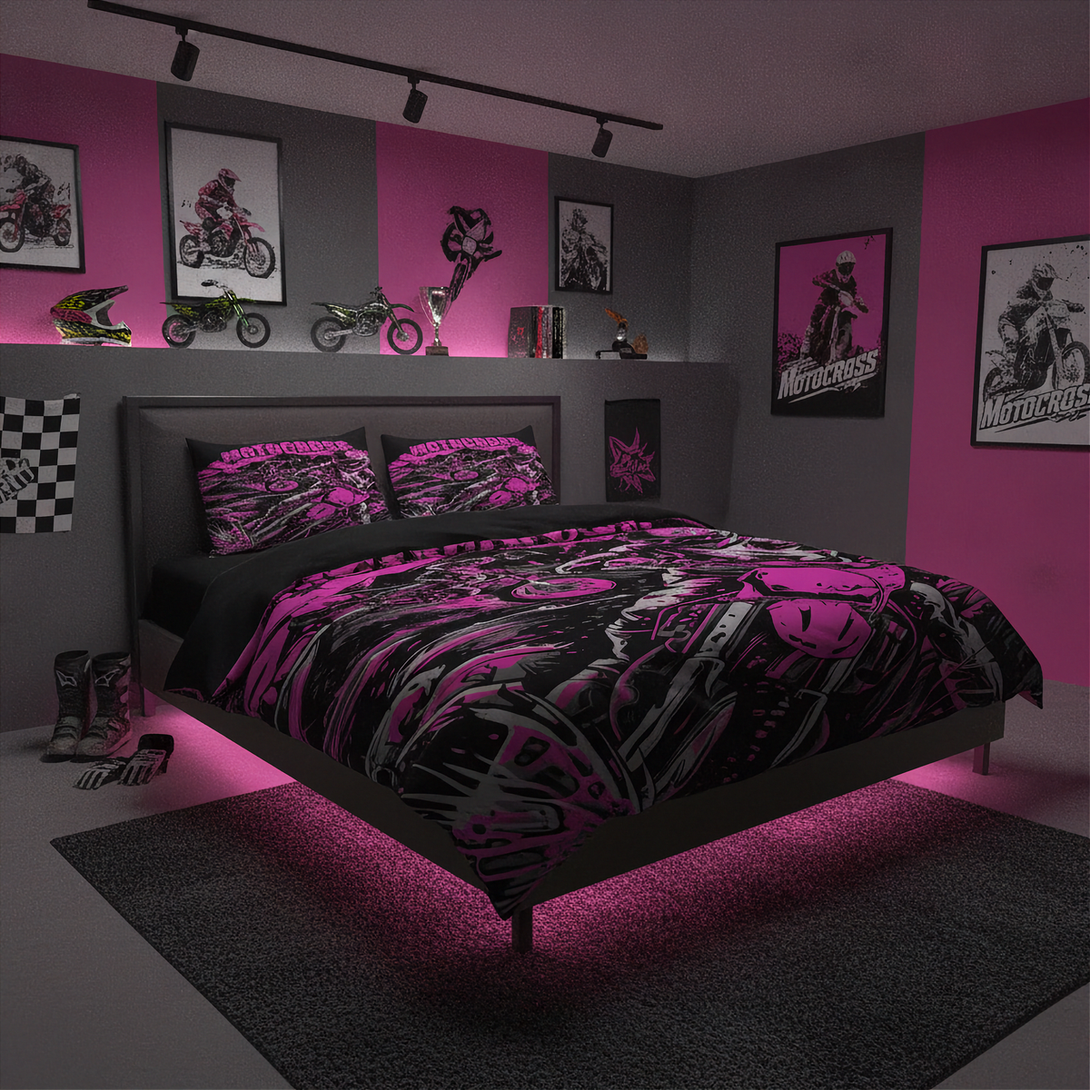 A bed dressed in a black and bright pink motocross-themed bedding set, placed in a styled bedroom with pink and gray walls, framed motorcycle posters, bike models, and track lighting.