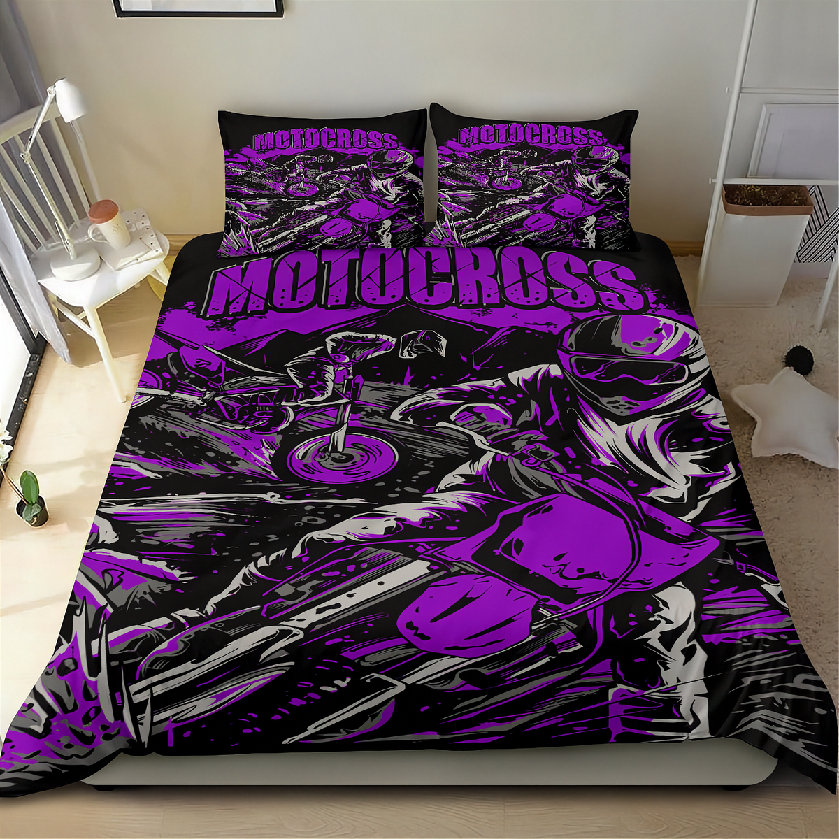 A motorcycle-themed bedding set featuring a black and purple graphic print with the word 'MOTOCROSS' and illustrated riders and bikes, shown on a bed in a bedroom setting.
