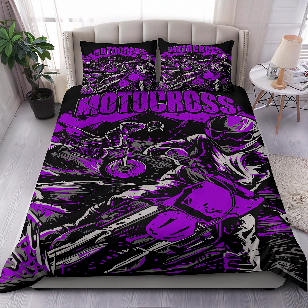 A bed dressed in a motocross-themed bedding set with a large purple and black graphic print featuring a motorcycle and the word 'MOTOCROSS' across the duvet and matching pillowcases, shown in a styled bedroom setting.