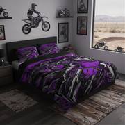 A bed dressed in a motocross-themed bedding set with a bold purple, black, and white graphic print, styled in a modern bedroom with dirt bike wall decals and a window view of a desert track.