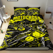 A motocross-themed bedding set featuring a duvet cover and two pillowcases with a bold black, yellow, and gray graphic print of a motorcycle racer, shown on a bed in a bedroom setting.