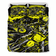 A motocross-themed bedding set featuring a duvet cover and two matching pillowcases with a high-contrast graphic print in neon yellow, black, and gray showing a rider and motorcycle.