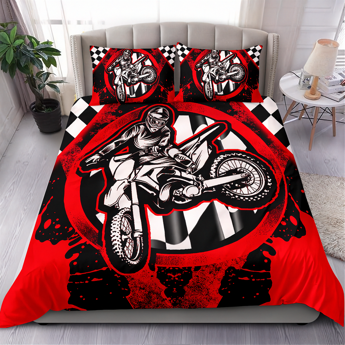A motocross-themed bedding set featuring a duvet cover and two matching pillowcases with a bold graphic print of a rider on a dirt bike over a red, black, and white checkered design, displayed on a bed in a modern bedroom setting.