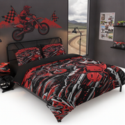 A kids' bedroom featuring a bed styled with a red, black, and gray graphic duvet cover and matching pillowcases. The room has a dark gray wall decorated with a red dirt bike wall decal, a window showing a dirt road outside, and toy vehicles on shelves.