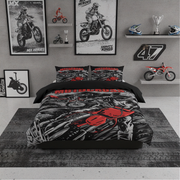 A motorcycle-themed bedding set displayed on a bed in a styled room. The set includes a duvet cover and two matching pillowcases with a black, gray, and red graphic print featuring a dirt bike and the word 'MOTORCYCLE'.