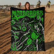 Woman holding a motocross-themed blanket with a dirt bike track in the background