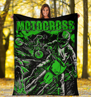 Woman holding a 'Motocross' themed blanket with graphics of a rider and bike in a forest setting.