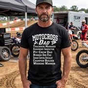 Man wearing a black t-shirt with 'Motocross Dad' text at a motocross event.