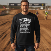 Man wearing a black sweatshirt with 'Motocross Dad' text on a dirt track background
