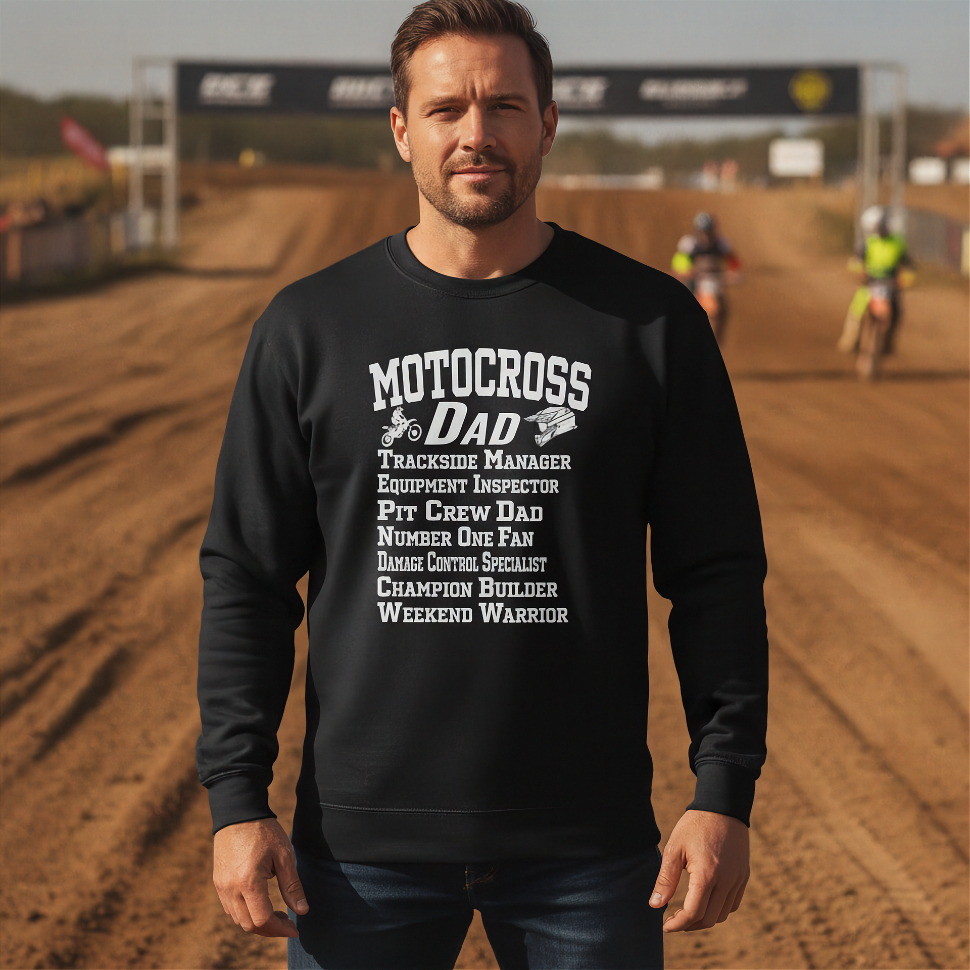 Man wearing a black sweatshirt with 'Motocross Dad' text on a dirt track background