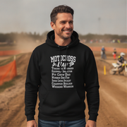 Man wearing a black hoodie with 'Motocross Dad' text at a dirt track.