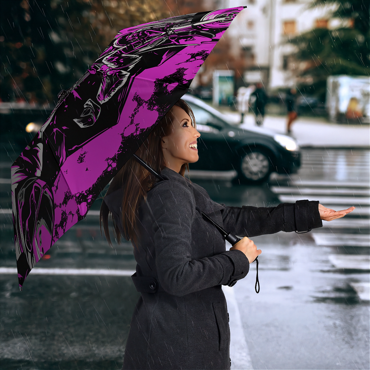 A woman in a dark gray coat holding a large open umbrella with a bold black and magenta graphic print, standing on a wet city street in the rain.