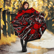 A woman holding an open umbrella in an outdoor autumn setting. The umbrella features a bold graphic print of a motorcyclist in red, black, and white, with the word 'Motocross' printed vertically on the side.