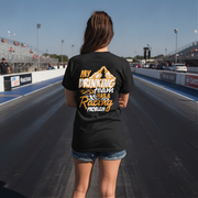 Woman wearing a black t-shirt with humorous text on a race track