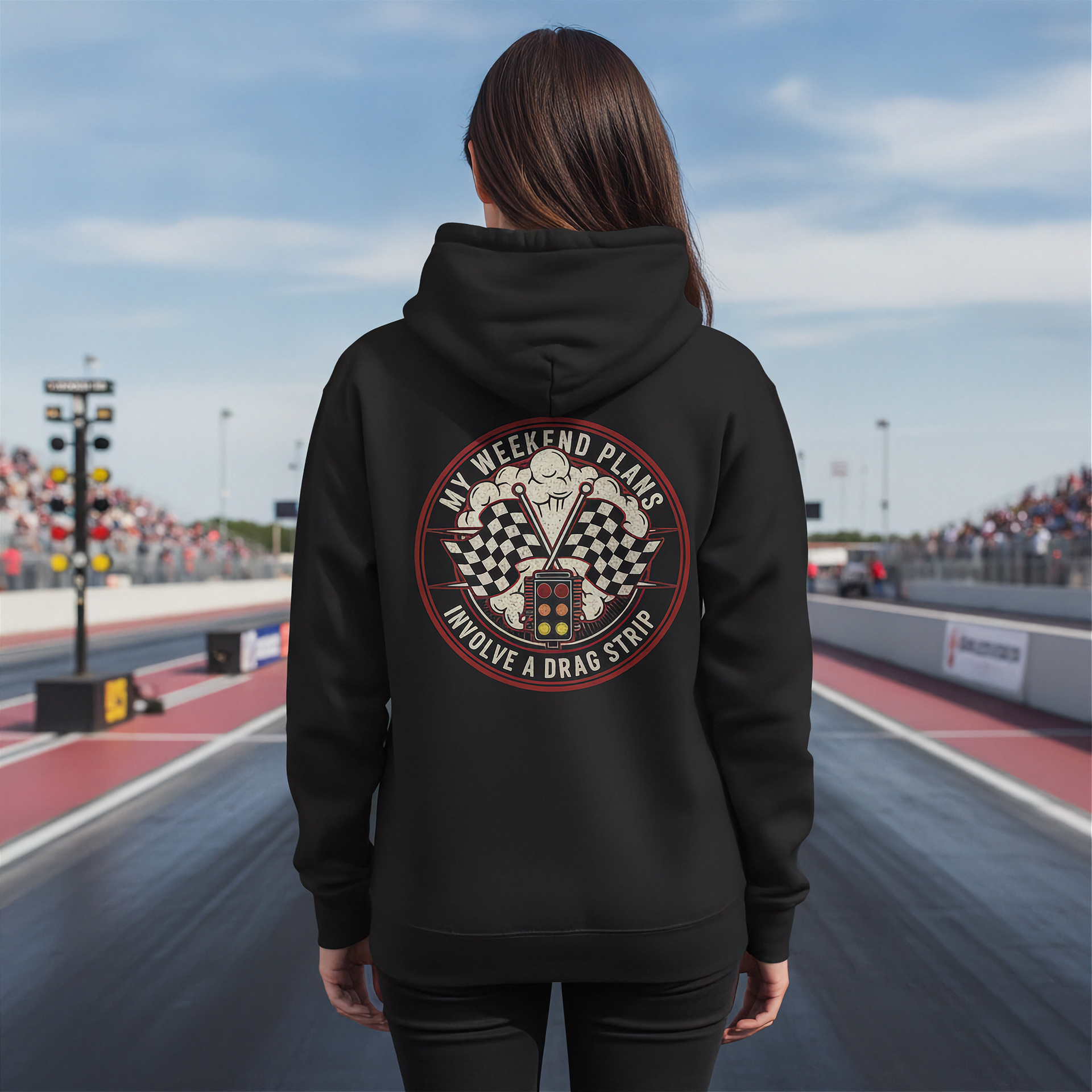 Woman wearing a black hoodie with a drag racing graphic on a race track