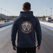 Man wearing a hoodie with a drag racing graphic on a racetrack