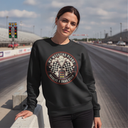 Woman wearing a black sweatshirt with a graphic design on a race track