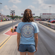 Woman wearing a blue t-shirt with a logo on a race track