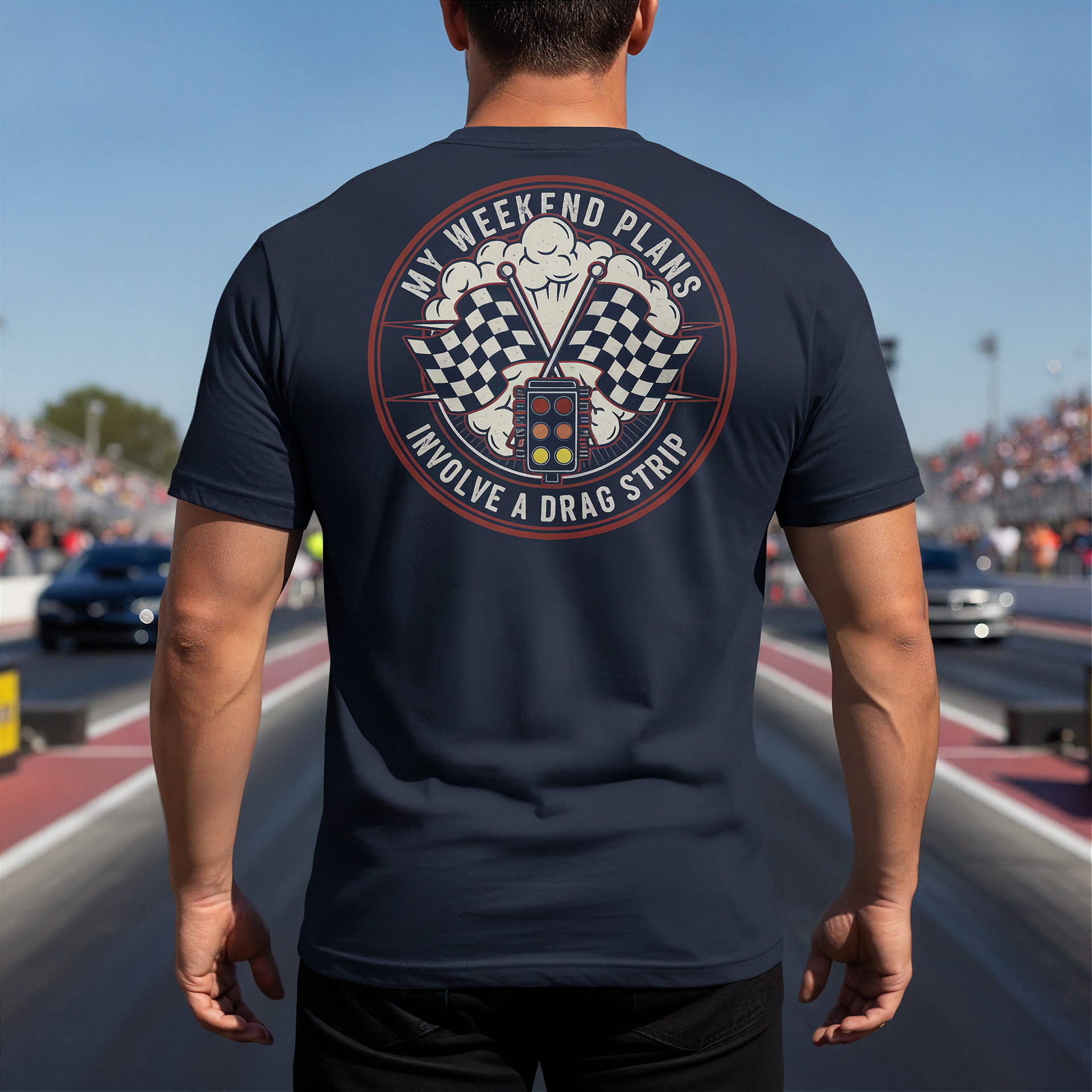 Person wearing a navy blue t-shirt with a graphic design on the back at a race track.