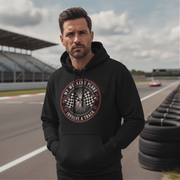 Man wearing a black hoodie with a graphic design on a race track