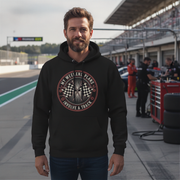 Man wearing a black hoodie with a graphic design on a race track