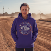 Woman wearing a purple hoodie with a track-themed design on a dirt track background